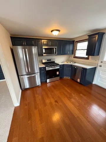 a kitchen with stainless steel appliances granite countertop a refrigerator a sink dishwasher a stove and a microwave oven on granite countertops