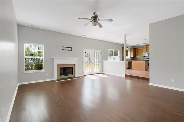 wooden floor fireplace and windows in an empty room