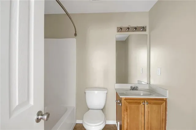 a bathroom with a toilet a sink and mirror
