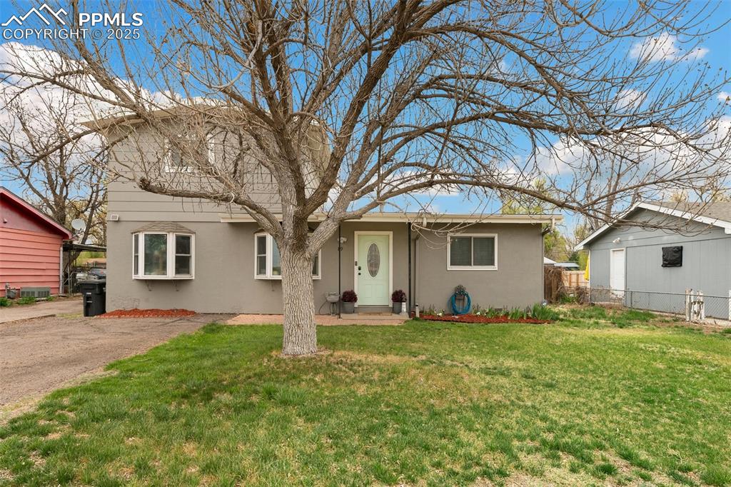 a front view of house with yard and trees around