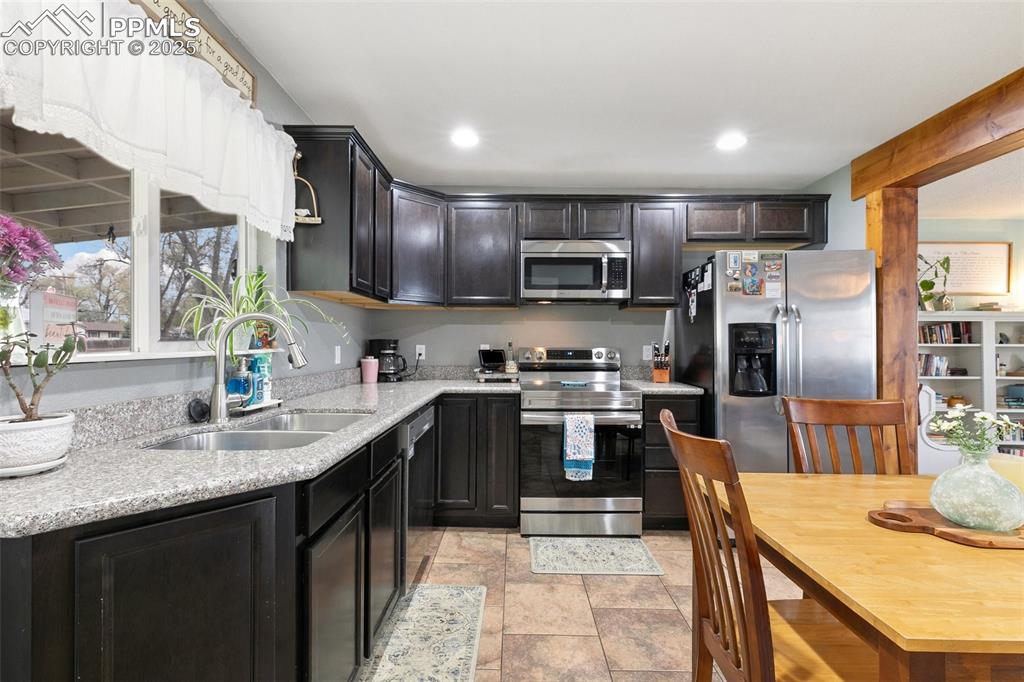 89 Security Boulevard Colorado Springs, CO 80911 - Photo 11 of 29 a kitchen with kitchen island granite countertop a sink counter top space appliances and cabinets