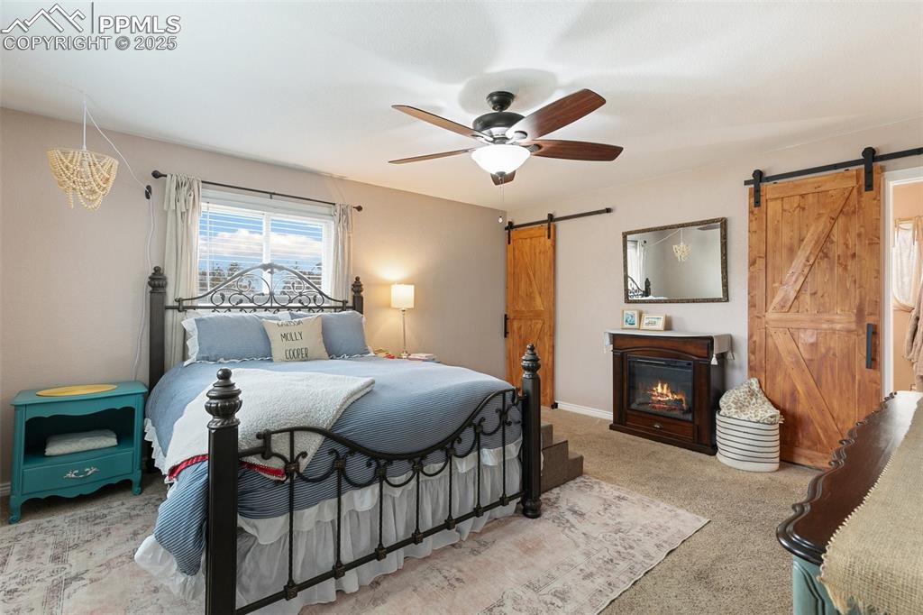 89 Security Boulevard Colorado Springs, CO 80911 - Photo 14 of 29 a bedroom with a bed a chandelier and dresser