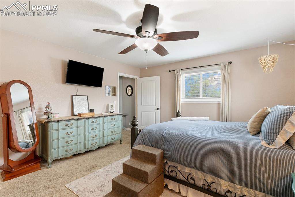 89 Security Boulevard Colorado Springs, CO 80911 - Photo 15 of 29 a bedroom with a large bed and a flat tv screen on dresser