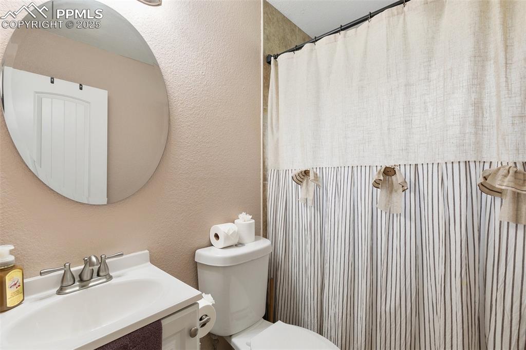 89 Security Boulevard Colorado Springs, CO 80911 - Photo 20 of 29 a bathroom with a sink a toilet and a mirror