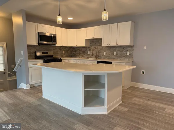 a kitchen with stainless steel appliances granite countertop a sink stove and microwave
