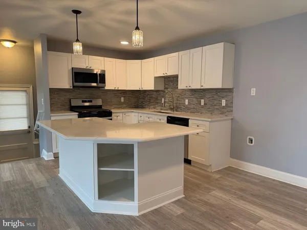 a kitchen with a stove a sink and a refrigerator