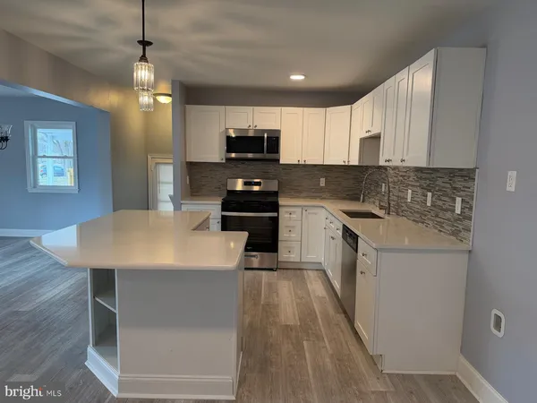 a kitchen with a sink a counter top space stainless steel appliances and cabinets