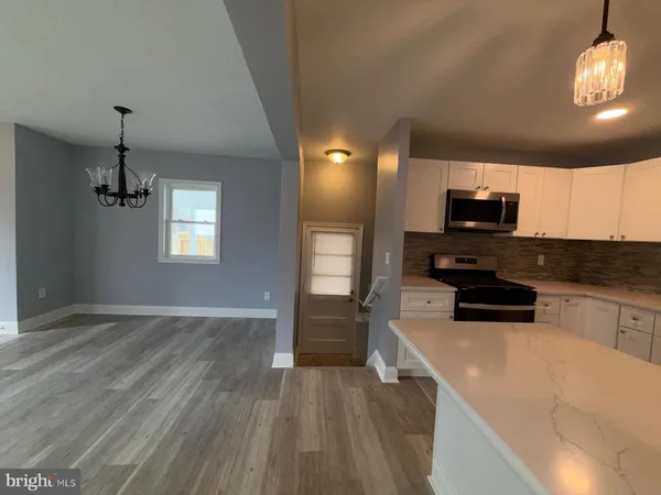 a kitchen with sink a microwave and cabinets