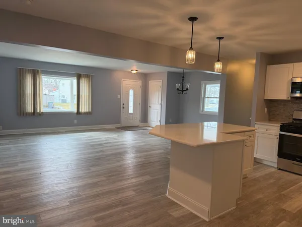 a view of a kitchen and dining room with wooden floor