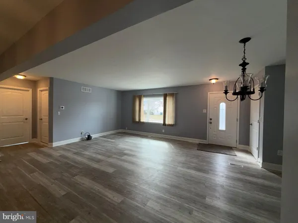 a view of empty room with wooden floor and window