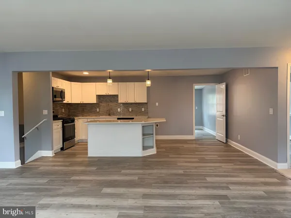 a large kitchen with kitchen island a sink stainless steel appliances and cabinets