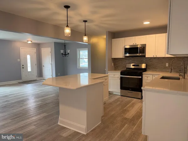 a kitchen with kitchen island a sink stainless steel appliances and cabinets