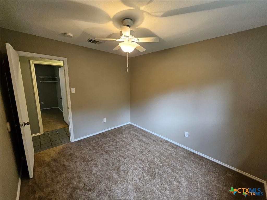 4402 Keota Drive Austin, TX 78749 - Photo 18 of 37 en empty room with a chandelier fan and hardwood floor