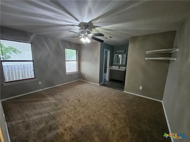 en empty room with windows and chandelier