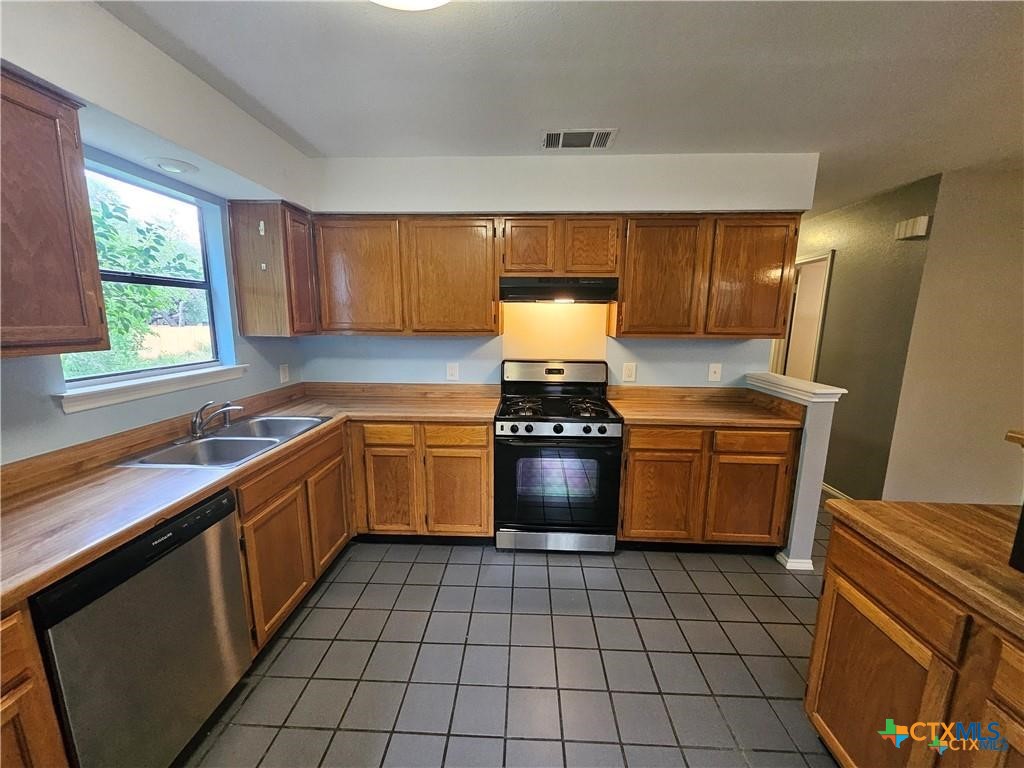 4402 Keota Drive Austin, TX 78749 - Photo 6 of 37 a kitchen with a stove sink and cabinets