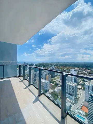 a view of a balcony with chairs and wooden floor