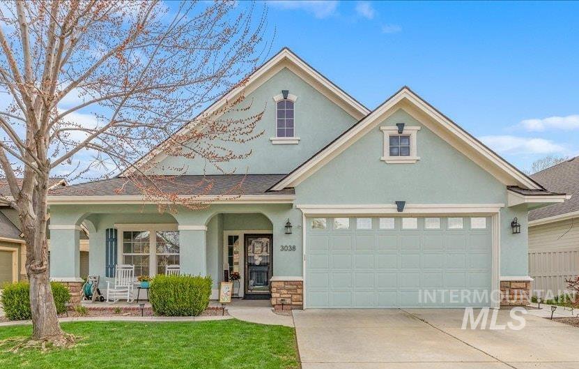 View of front of property featuring stucco siding, covered porch, concrete driveway, and a garage