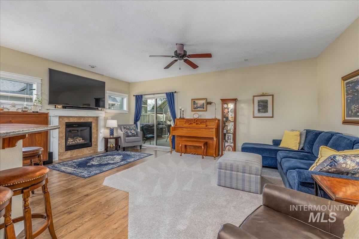3038 North Christian Way Meridian, ID 83646 - Photo 15 of 48 Living area with light wood-type flooring, a high end fireplace, a ceiling fan, and a textured ceiling