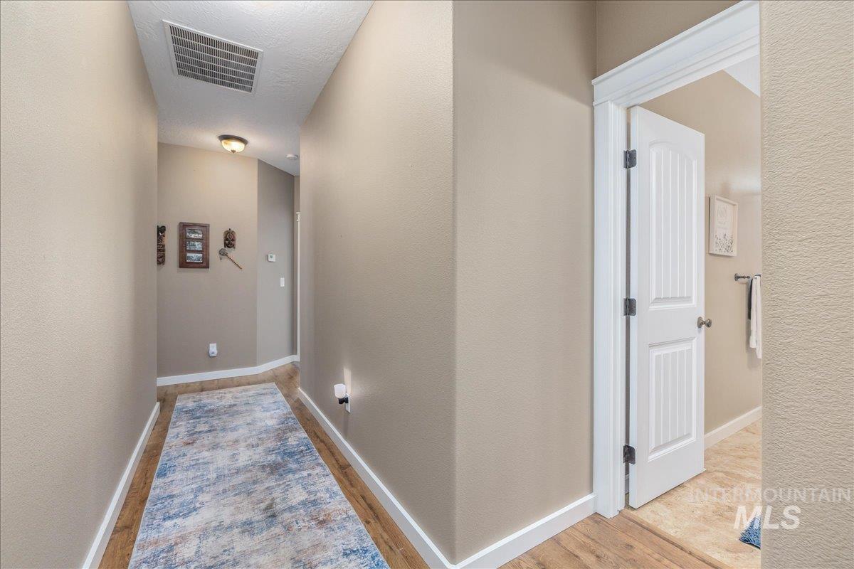 3038 North Christian Way Meridian, ID 83646 - Photo 30 of 48 Hallway with light wood-type flooring and a textured wall