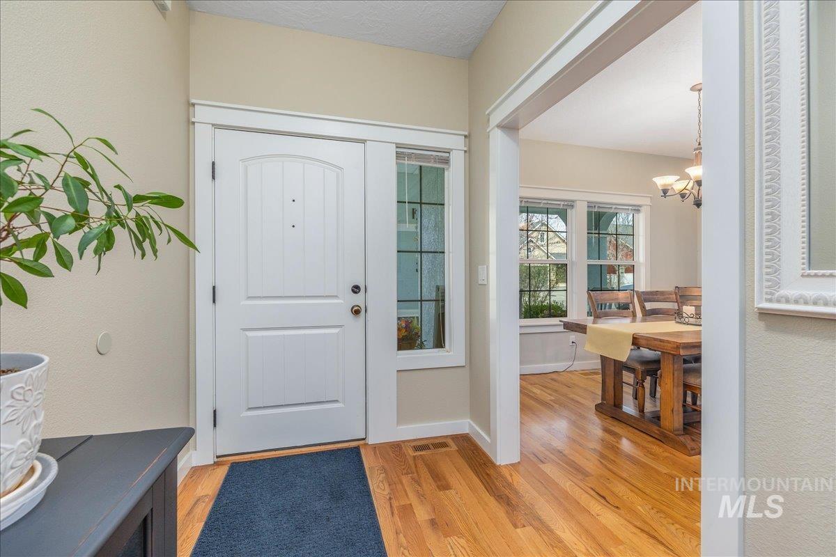 3038 North Christian Way Meridian, ID 83646 - Photo 6 of 48 Entryway featuring light wood finished floors and hanging lights