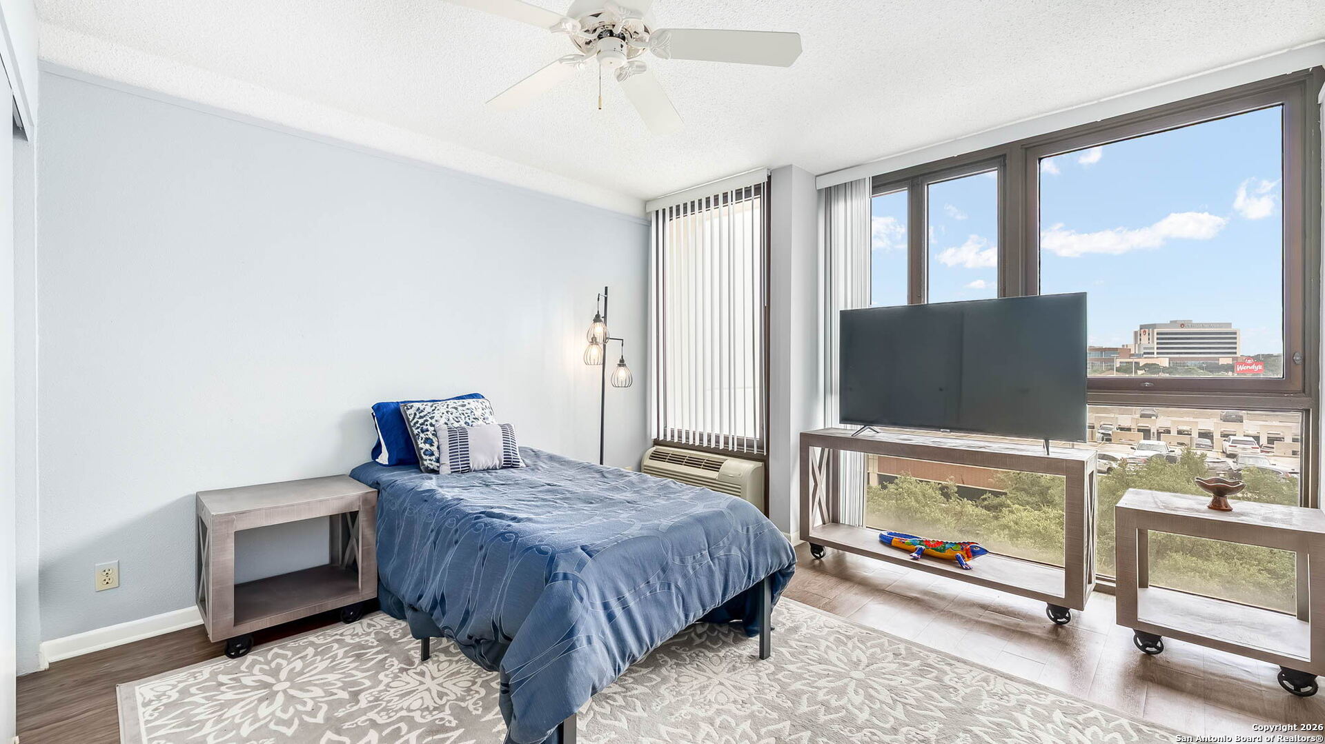 7701 Wurzbach Road, Unit 606 San Antonio, TX 78229 - Photo 5 of 10 a bedroom with a bed and glass wall