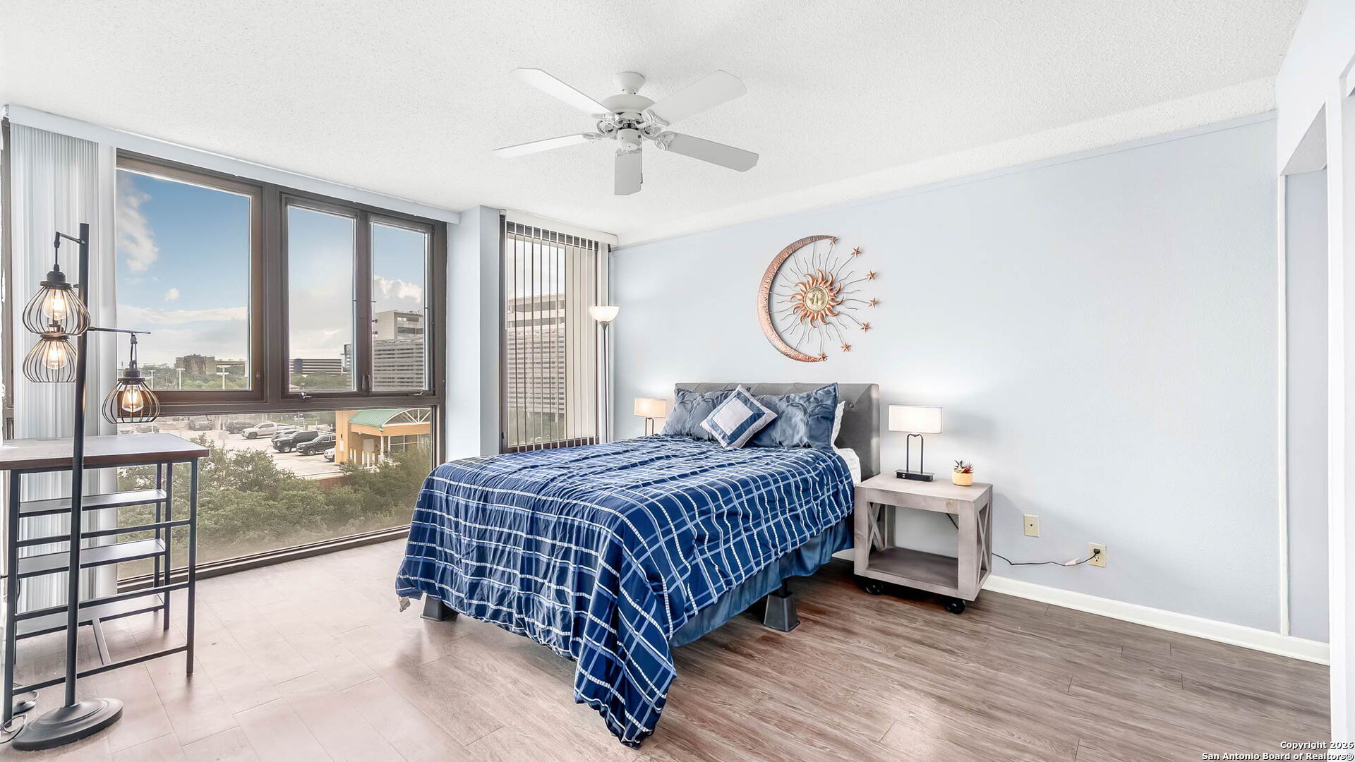 7701 Wurzbach Road, Unit 606 San Antonio, TX 78229 - Photo 6 of 10 a bedroom with a bed and a chandelier