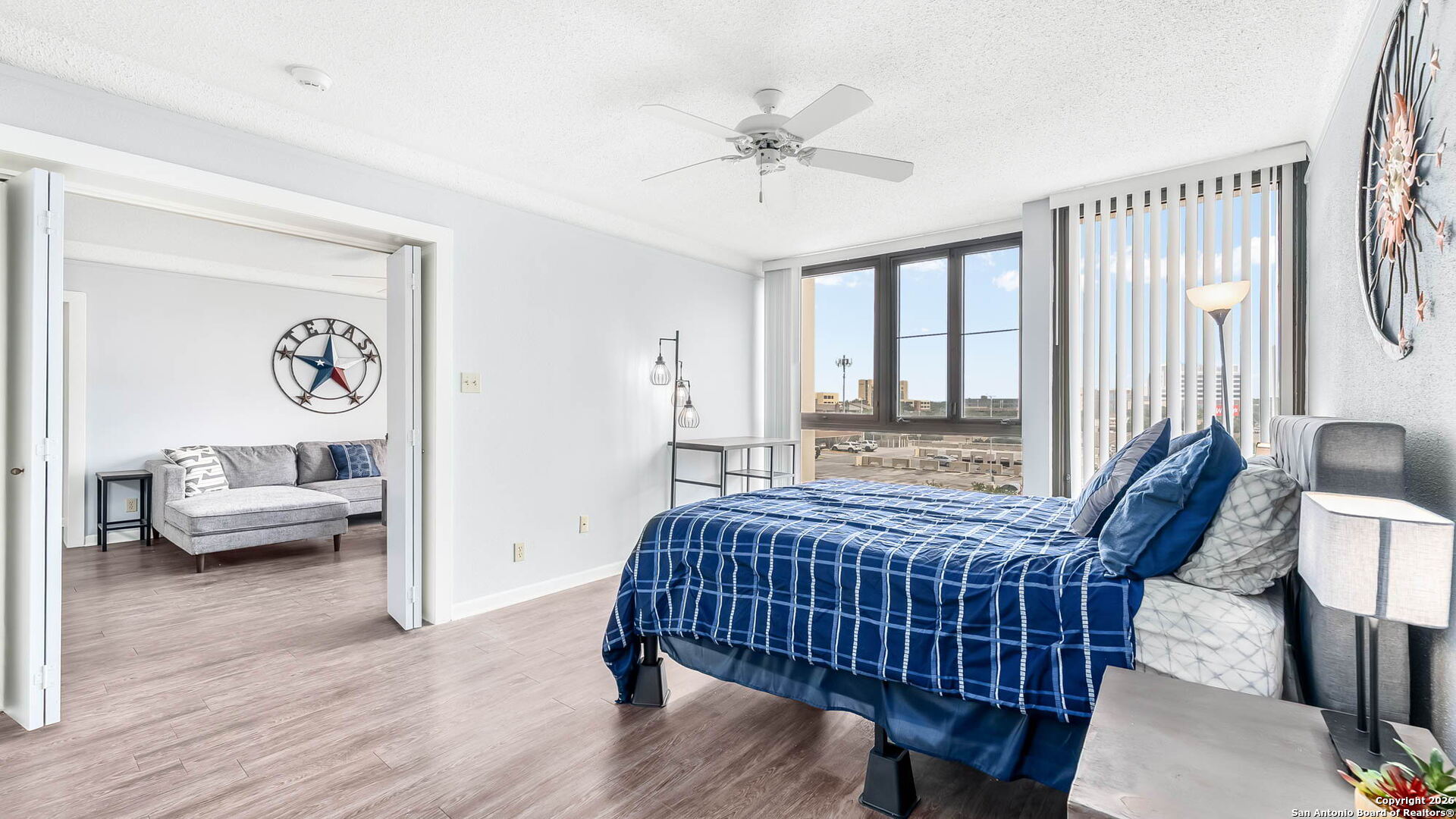 7701 Wurzbach Road, Unit 606 San Antonio, TX 78229 - Photo 7 of 10 a bedroom with a bed and wooden floor