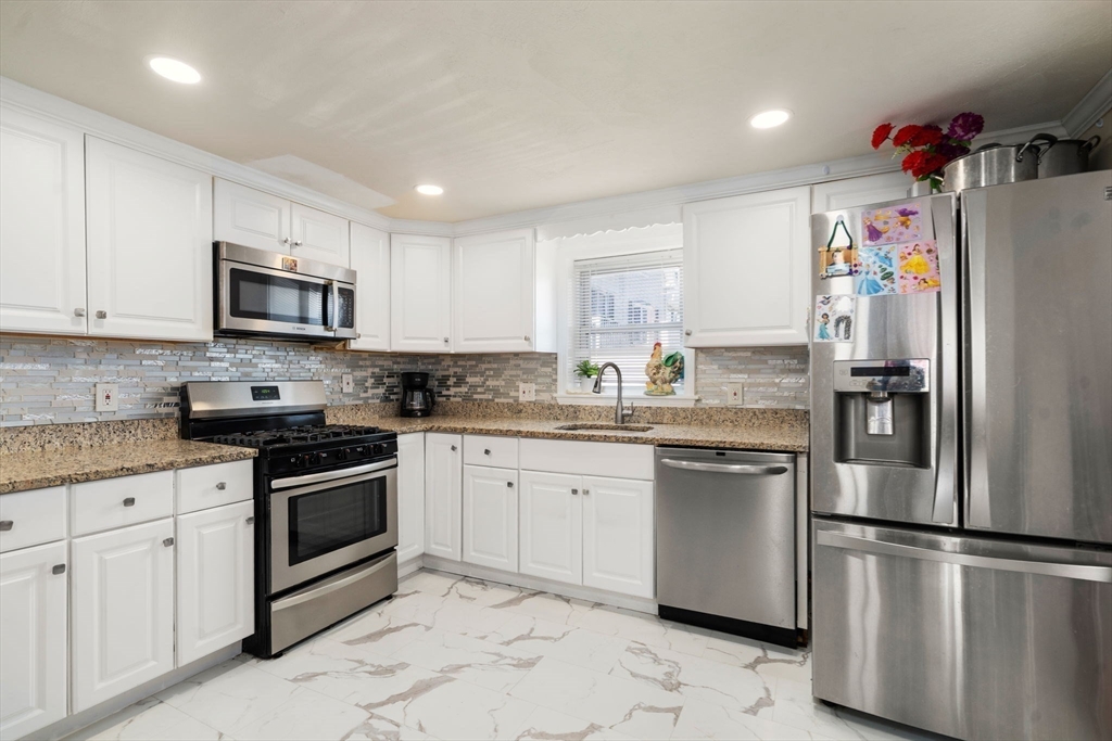 84 Howard Street Lawrence, MA 01841 - Photo 11 of 28 a kitchen with granite countertop white cabinets and stainless steel appliances