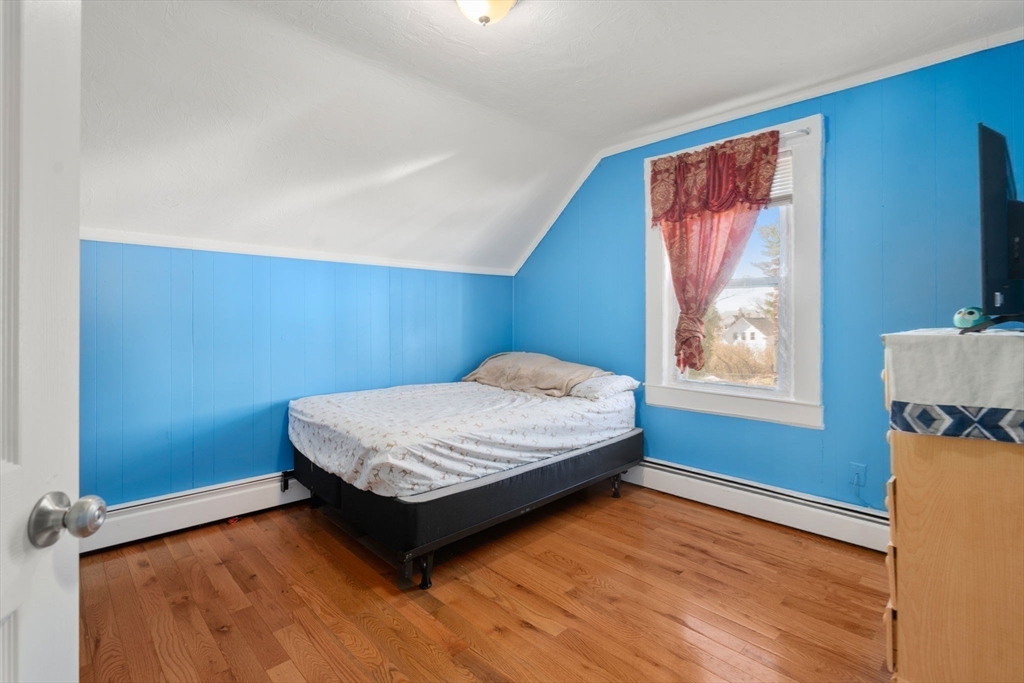 84 Howard Street Lawrence, MA 01841 - Photo 19 of 28 a bedroom with a bed and wooden floor