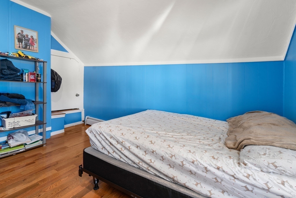 84 Howard Street Lawrence, MA 01841 - Photo 20 of 28 a bedroom with a bed and a wall painting