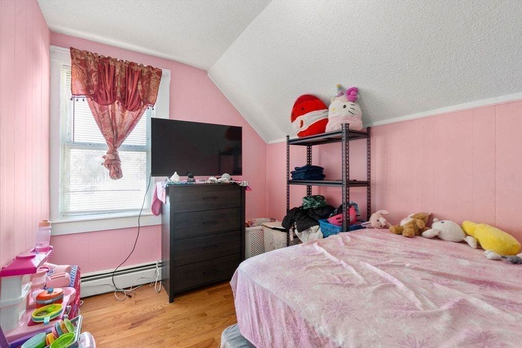 84 Howard Street Lawrence, MA 01841 - Photo 21 of 28 a bedroom with a bed and a flat screen tv