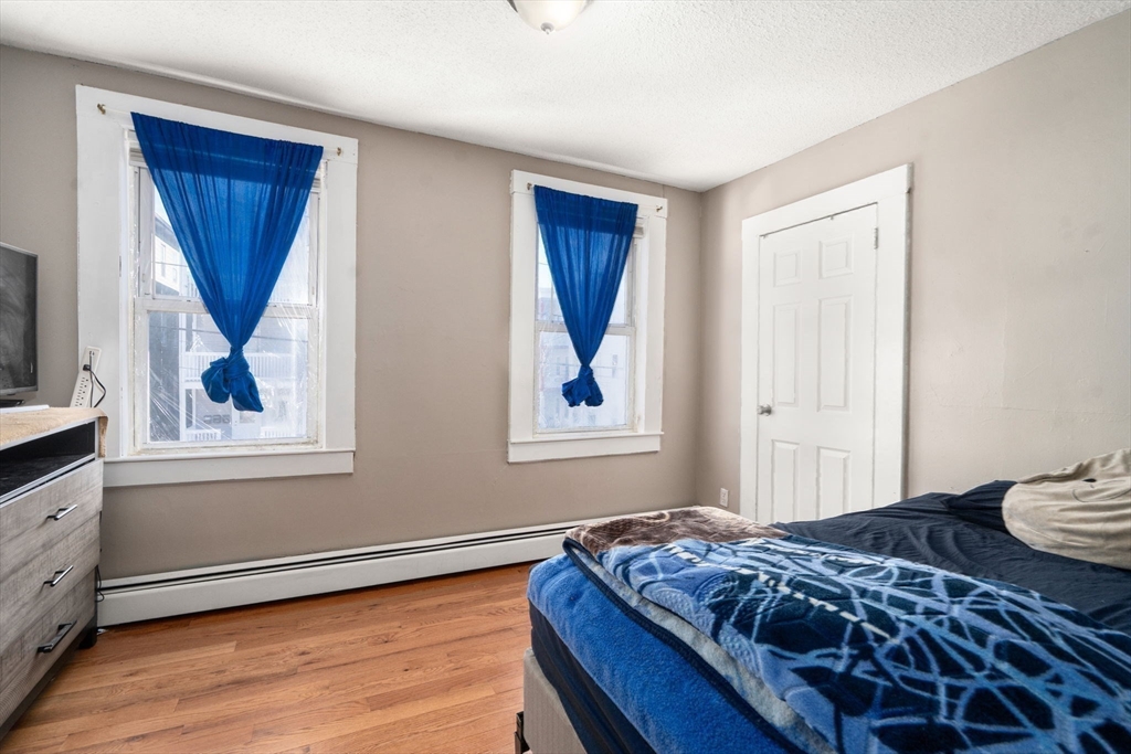 84 Howard Street Lawrence, MA 01841 - Photo 23 of 28 a bedroom with a bed and wooden floor