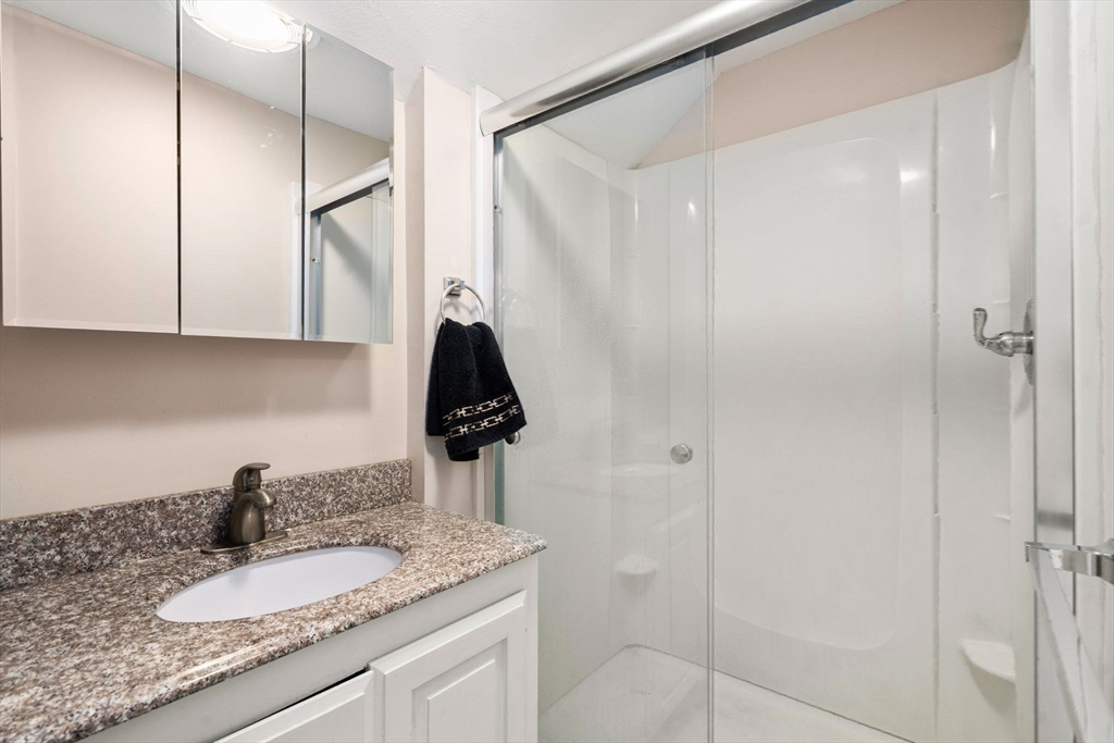 84 Howard Street Lawrence, MA 01841 - Photo 25 of 28 a bathroom with a granite countertop sink and a mirror