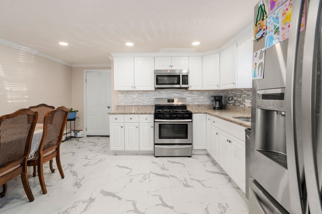 84 Howard Street Lawrence, MA 01841 - Photo 10 of 28 a kitchen with stainless steel appliances granite countertop a refrigerator sink and stove