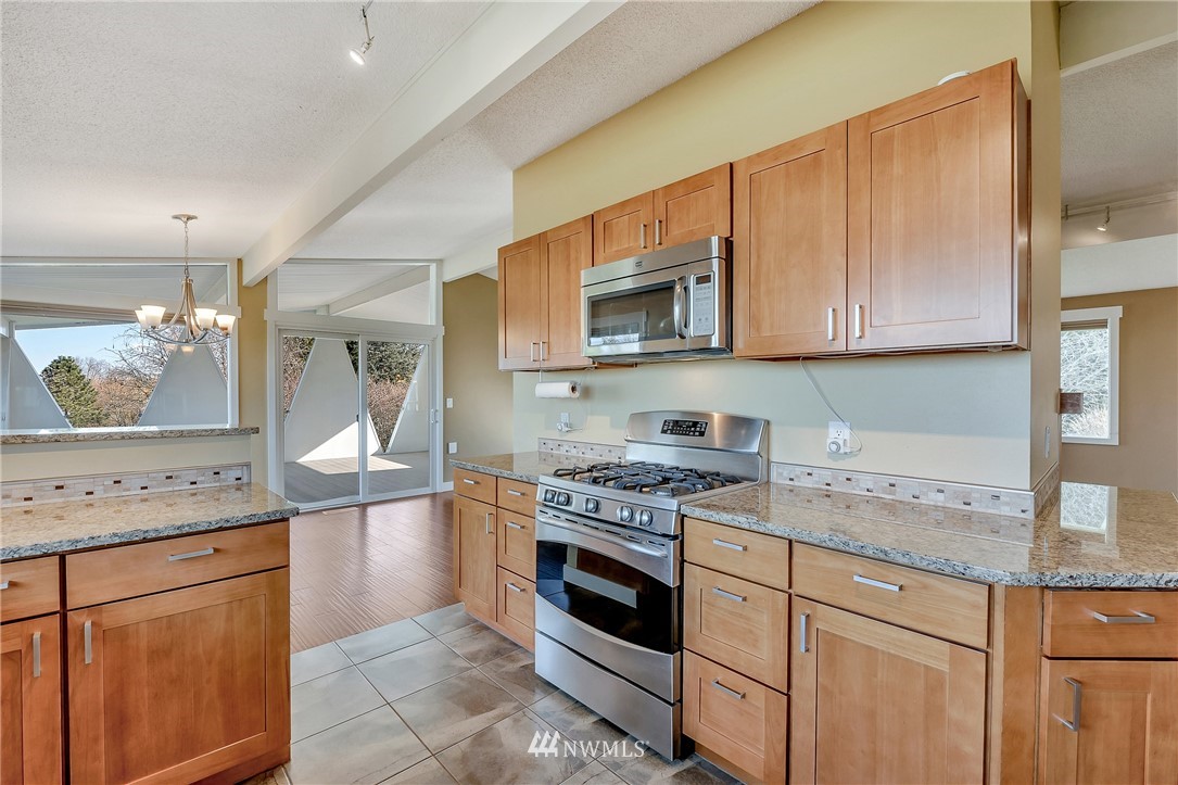 5874 Laurel Ridge Way Bellingham, WA 98226 - Photo 15 of 40 a kitchen with stainless steel appliances granite countertop a stove a sink and a microwave