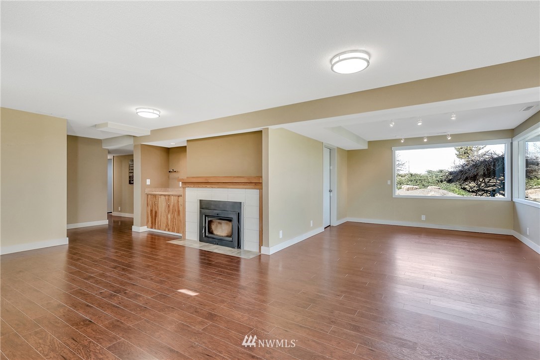 5874 Laurel Ridge Way Bellingham, WA 98226 - Photo 28 of 40 an empty room with wooden floor fireplace and windows