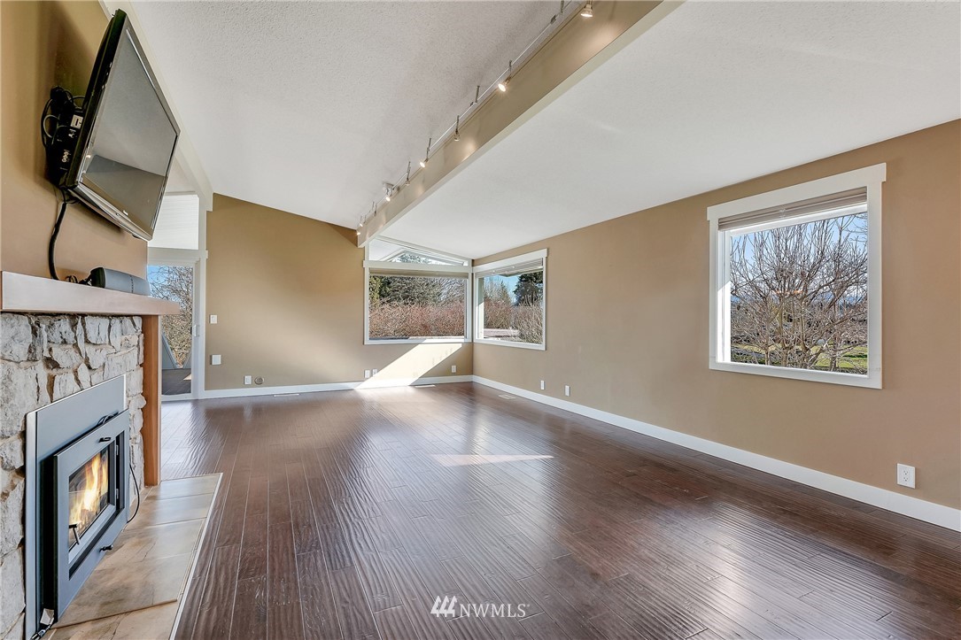 5874 Laurel Ridge Way Bellingham, WA 98226 - Photo 7 of 40 a view of an empty room with wooden floor and a fireplace