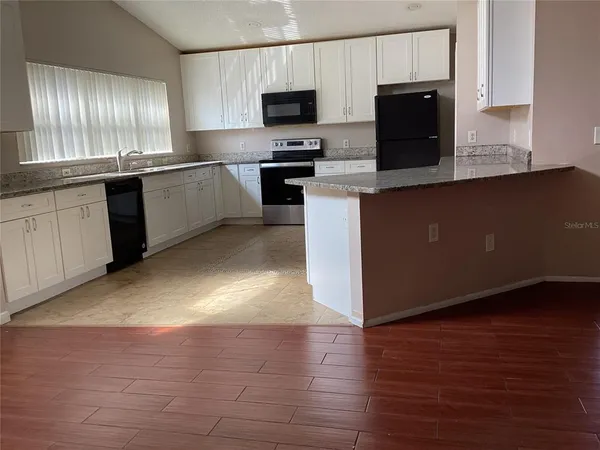 a kitchen with a sink a stove a microwave and refrigerator