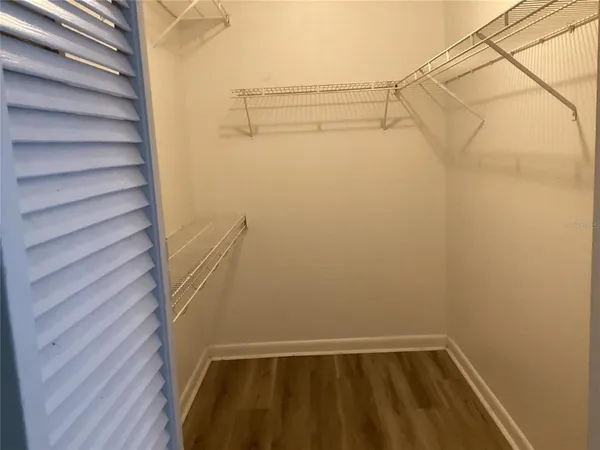 an empty room with wooden floor fireplace and windows