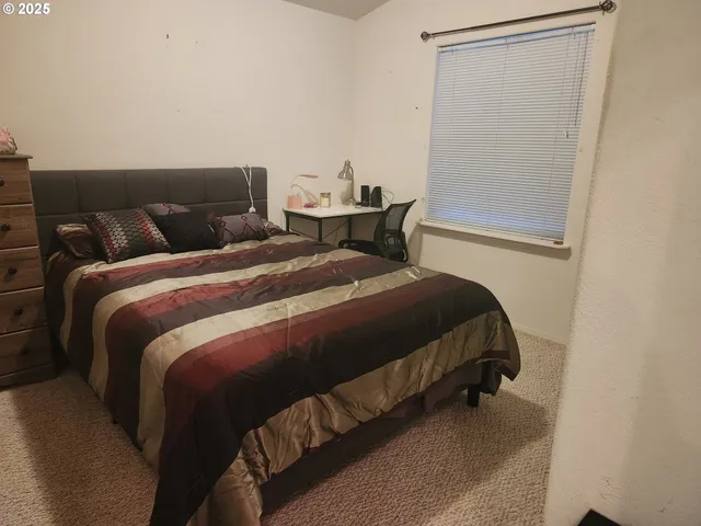 a bedroom with a bed and table