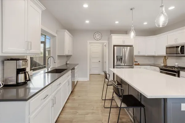 a large kitchen with granite countertop lots of counter space and refrigerator