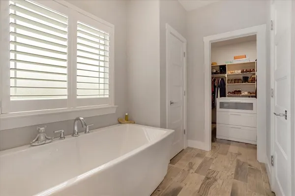 a bathroom with a tub sink and mirror