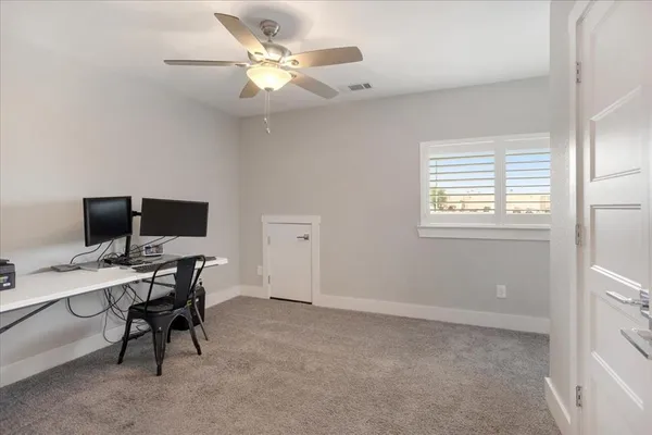 a view of a workspace with furniture and a window