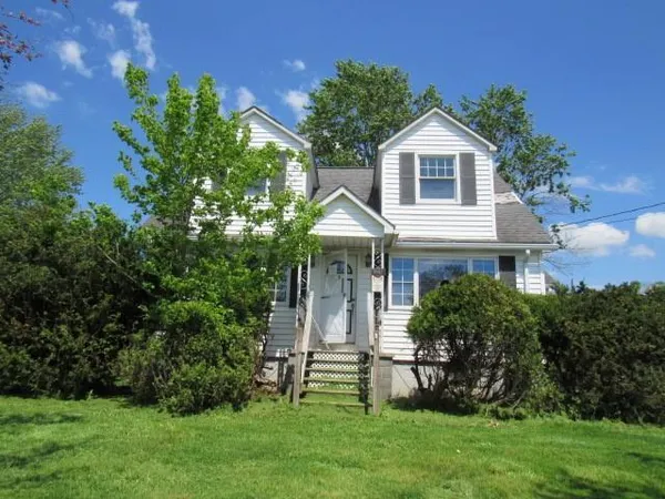 a front view of a house with a garden and plants