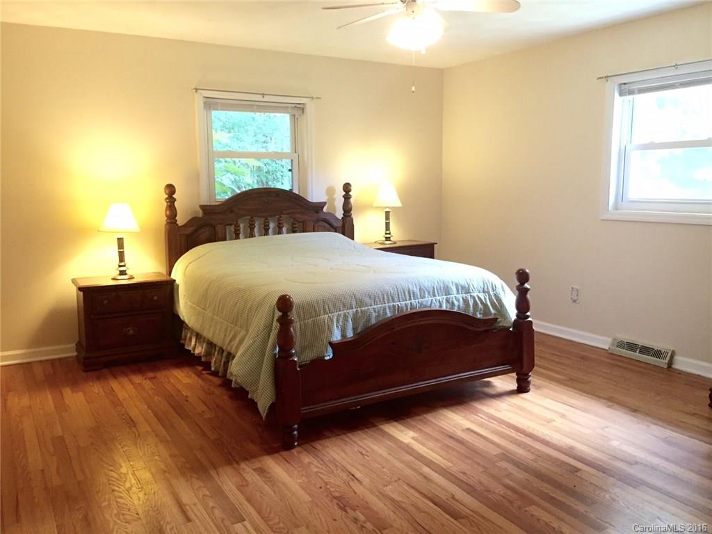 126 Pea Ridge Road Mill Spring, NC 28756 - Photo 11 of 24 a bedroom with a bed and wooden floor
