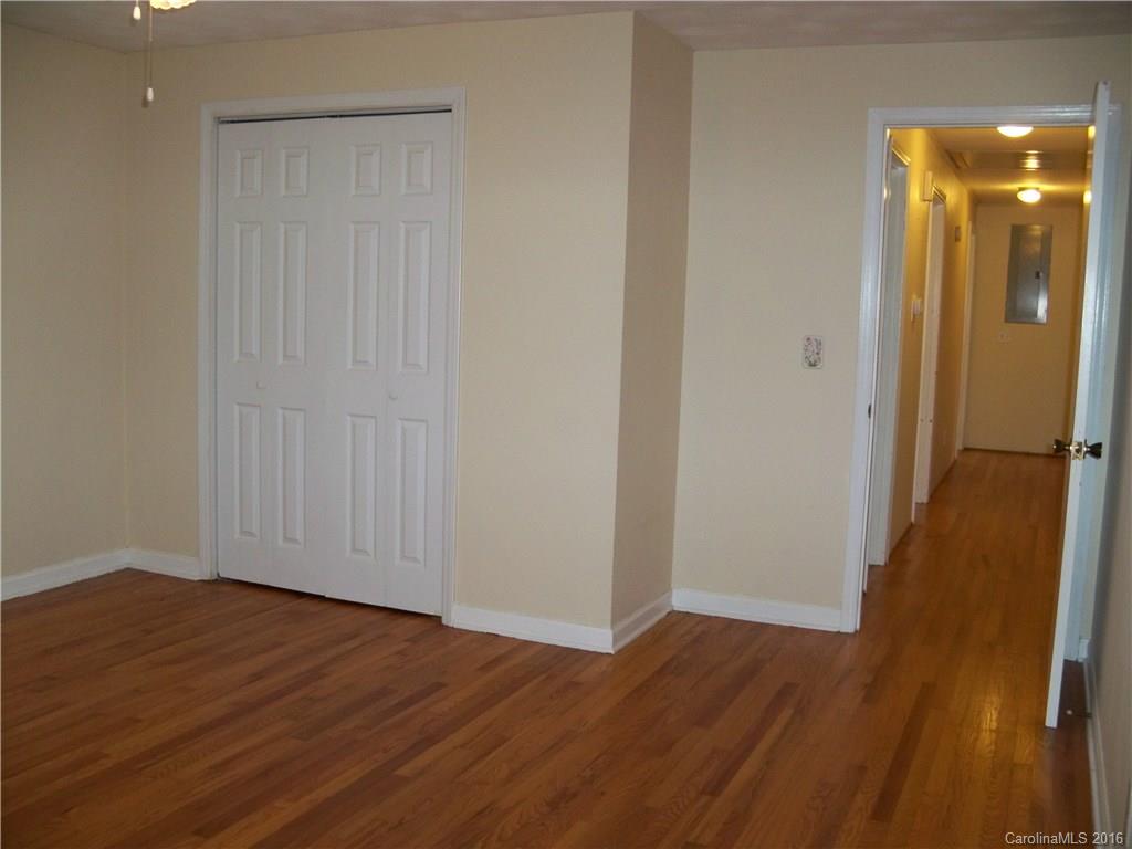 126 Pea Ridge Road Mill Spring, NC 28756 - Photo 12 of 24 a view of an empty room with wooden floor and a bathroom