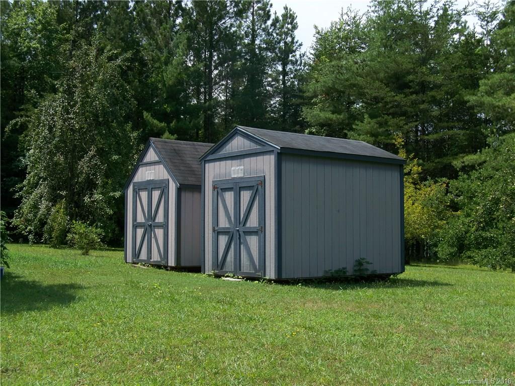 126 Pea Ridge Road Mill Spring, NC 28756 - Photo 17 of 24 a wooden house with huge green field in front of it