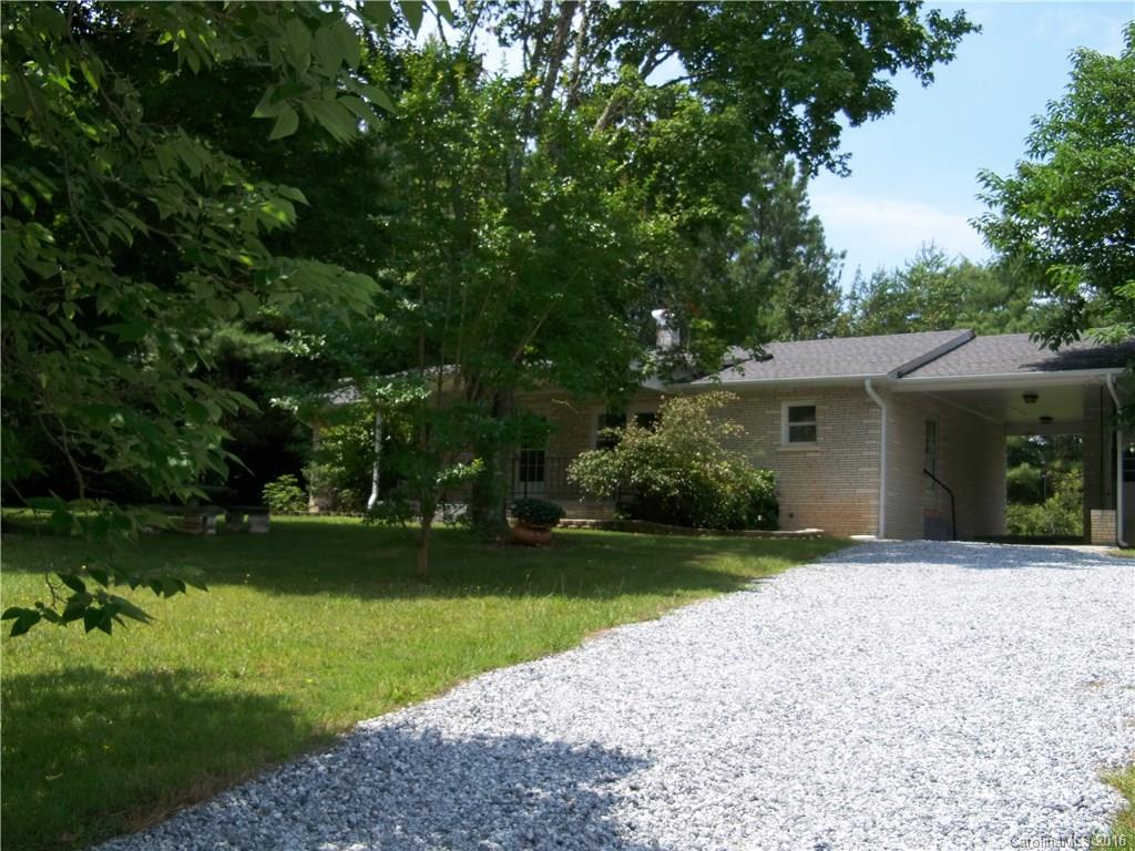 126 Pea Ridge Road Mill Spring, NC 28756 - Photo 20 of 24 a front view of a house with a garden and trees