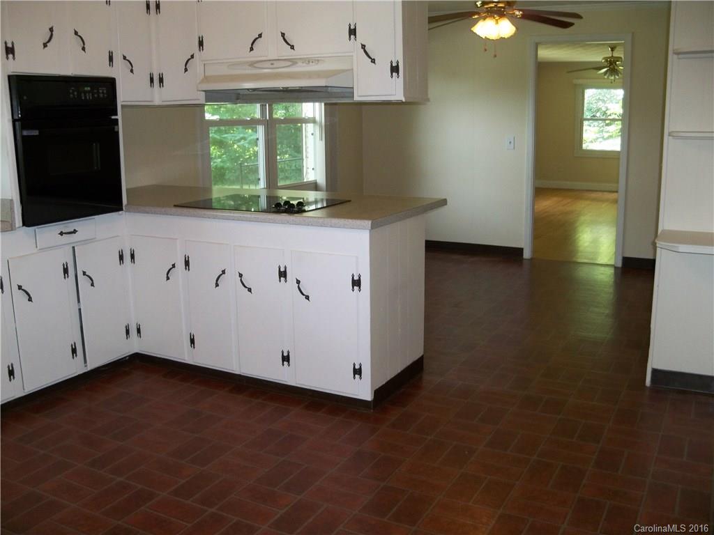 126 Pea Ridge Road Mill Spring, NC 28756 - Photo 9 of 24 a kitchen with stainless steel appliances granite countertop a sink a stove and a microwave oven