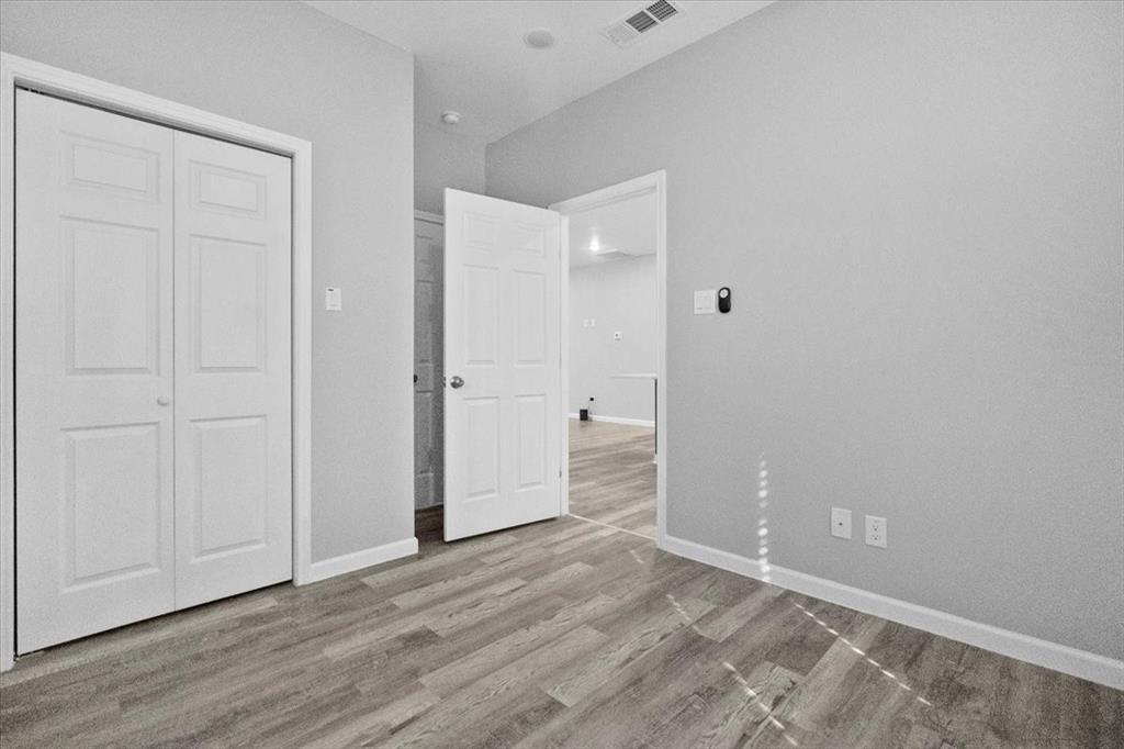 3512 Hamilton Avenue Dallas, TX 75210 - Photo 21 of 23 Unfurnished bedroom with light wood-style flooring and a closet